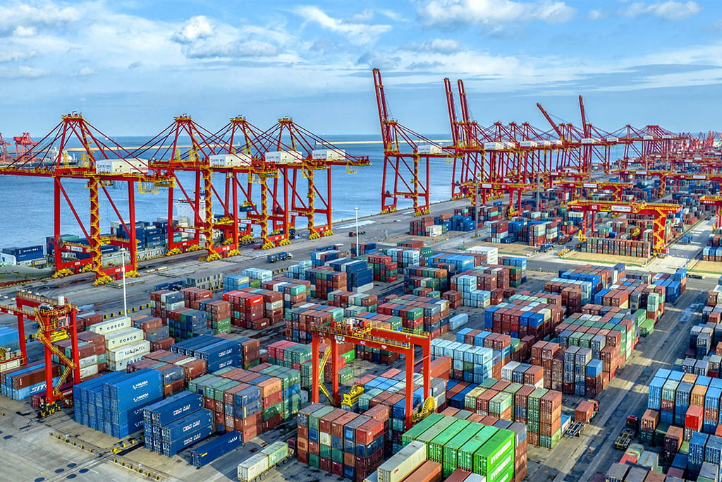 Shipping containers at a seaport terminal showing indoor playground equipment cargo arriving at the destination port.